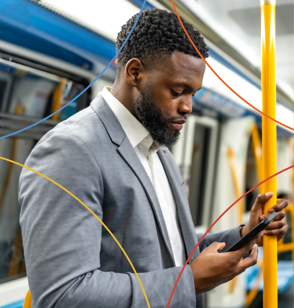 Blink Insurance end customer using phone to check for updates on their service travelling on the train holding rail